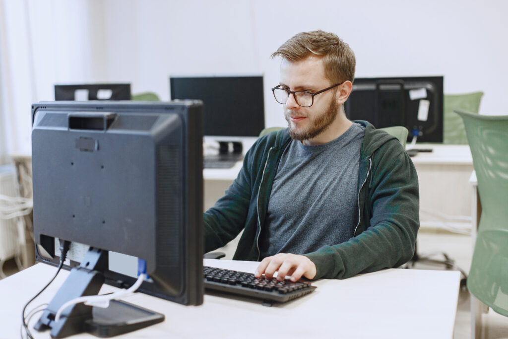 Man with glasses is sitting at the computer.